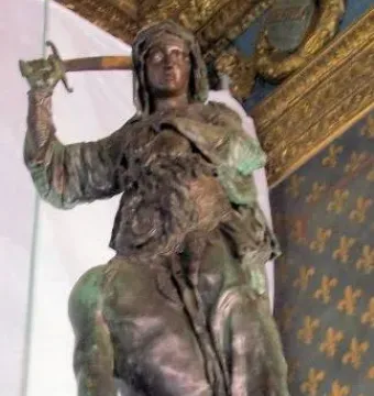 Judith and Holofernes bronze sculpture with a raised sword over a slumped figure and severed head
