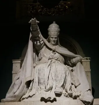 White marble statue of Pope Clement XIV from his tomb, seated in elaborate robes with one arm raised.