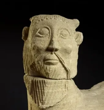 Bicha de Balazote stone sculpture showing a bearded human-like head with horn-like protrusions