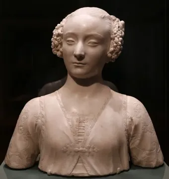 Marble bust of a young woman with tightly curled hair and an ornate carved garment.