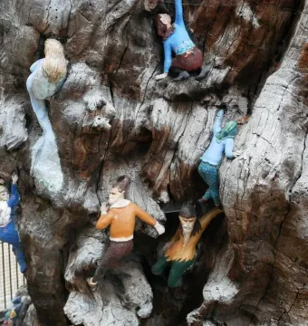 Detail of the Elfin Oak showing colorful sculpted figures embedded in a weathered tree trunk.
