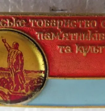 Commemorative badge featuring a circular emblem with the Lenin Monument in Zaporizhzhia and Cyrillic text on a red and light blue background.