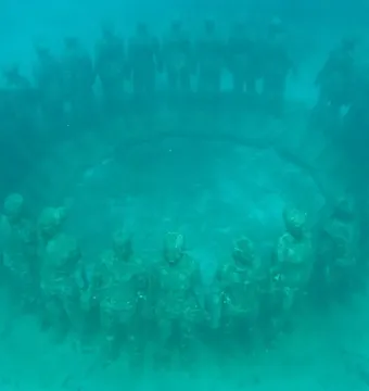 Molinere Underwater Sculpture Park with human-like sculptures arranged in a circle on the seabed