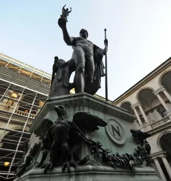 Napoleon as Mars the Peacemaker bronze statue on an ornate pedestal in a courtyard, with classical buildings behind it.