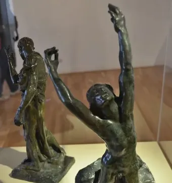 The Prodigal Son bronze statue of a kneeling nude man with arms raised and head thrown back, with another robed figure behind him.