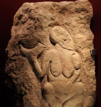 Venus of Laussel stone relief of a nude female figure holding a crescent-shaped object.