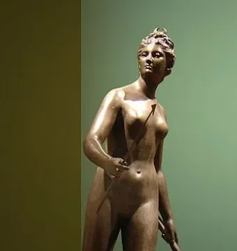Diana bronze sculpture of a nude female figure holding an arrow and bow in a dynamic pose.