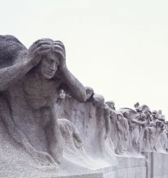 Stone figures in Lorado Taft\'s Fountain of Time, with a distressed figure in the foreground and a procession of carved people receding along the curved sculpture.