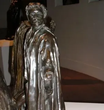 Bronze sculpture of Jean de Fiennes by Auguste Rodin, shown in a draped cloak with one hand holding a ring-like object.