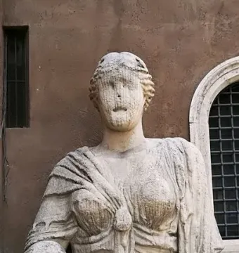Madama Lucrezia stone bust with draped figure and coiled hair against a brick wall