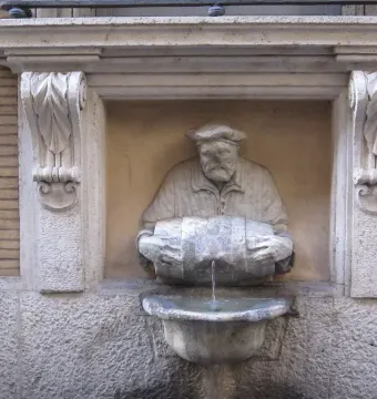 The Porter fountain statue of a bearded man in a cap pouring water from a barrel into a basin.