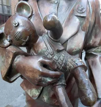 Bronze figure in Trains to Life – Trains to Death holding a stitched toy bear