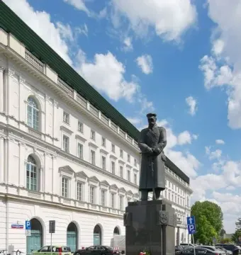 Józef Piłsudski Monument on a dark granite pedestal with red and white wreaths at its base.