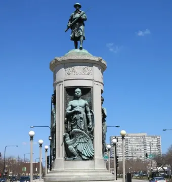Victory Monument with bronze statues, including a soldier atop the monument and figures in lower niches.