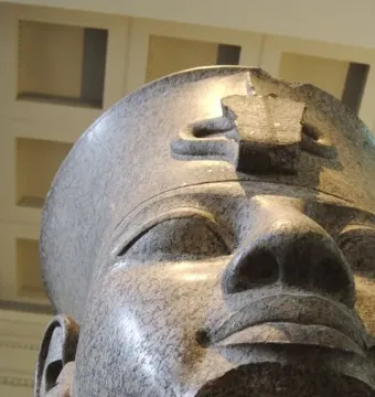 Granite head of Amenhotep III with a damaged crown and a missing section below the mouth
