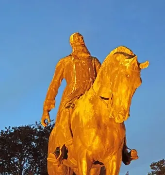 Leopold II equestrian statue in warm golden light against a twilight sky