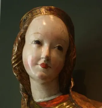 Close-up of the crowned Madonna of Krużlowa with painted face and colorful robes.