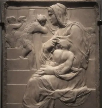 Madonna of the Stair stone relief showing a seated woman holding a child, with smaller figures on the stairs behind them.