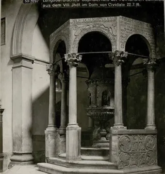 The Baptistry of Callistus, showing an octagonal stone baptistery with slender columns, arched openings, and a carved baptismal font inside.