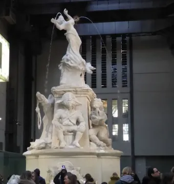 Fons Americanus sculpture in Tate Modern’s Turbine Hall, with visitors gathered around the base and water spraying from figures at the top.