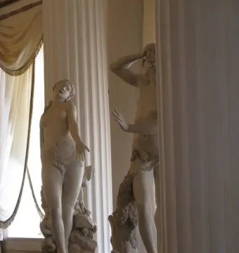 Orfeo y Eurídice marble sculpture with Eurydice reaching upward and Orpheus covering his head.