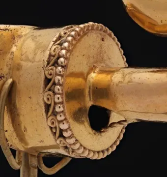 Serpent Labret with Articulated Tongue, showing a metallic ornament with beaded and filigree decoration on a stand.