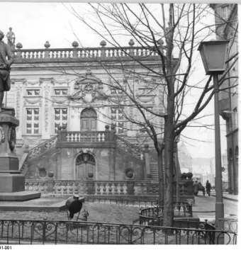 Goethe Monument stands on a tall pedestal in front of an ornate building in Leipzig.