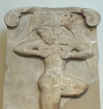 Runner Relief showing a weathered marble relief of a kneeling male figure in motion with styled hair and muscular detail.