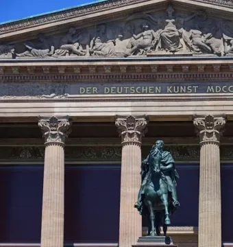 Frederick William IV equestrian statue in front of a classical building with columns and a sculpted frieze.