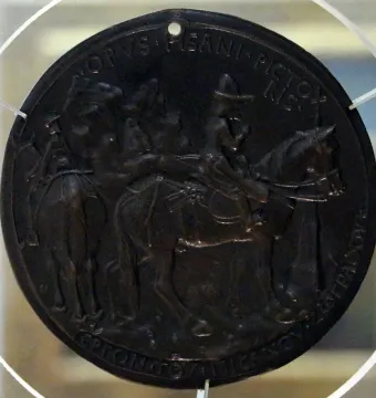 Reverse of the Medal of John VIII Palaiologos, showing a circular bronze relief with figures on horseback and inscriptions around the edge.
