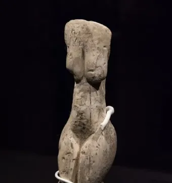 Venus of Eliseevichi ivory figurine on a mount against a dark background