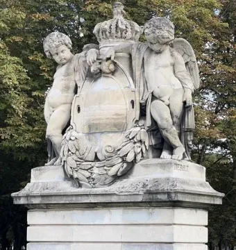 Weathered stone sculpture group of France crowning Art and Industry, with winged putti flanking a central crest and floral wreath.