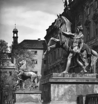 Two bronze Horse Tamers sculptures showing muscular men restraining rearing horses on stone pedestals.