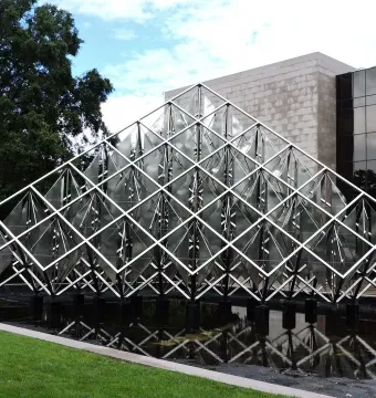 Delta Solar, a large silver geometric sculpture with fan-like elements above a reflective pool.