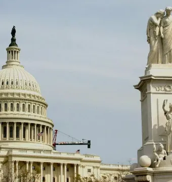 Peace Monument with allegorical figures, set against the U.S. Capitol dome and an overcast sky.
