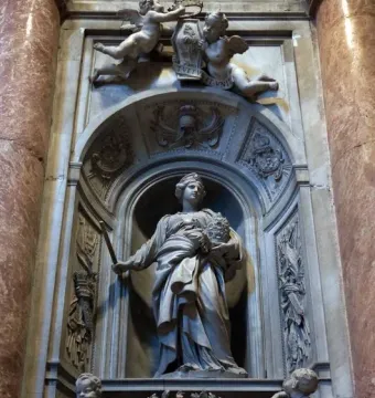 Tomb of Countess Matilda of Tuscany with a standing marble figure in an arched niche, flanked by cherubs and ornate carvings.