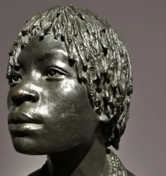 Woman of Central Africa bronze bust with short textured hair and layered beaded necklaces, shown in three-quarter profile.