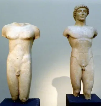 The Strangford Apollo marble statue beside a headless kouros torso, both shown from the chest down.