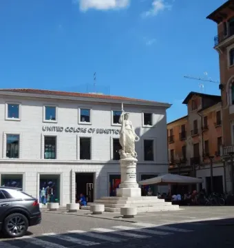 Monumento dell\'Indipendenza, a white marble statue of a draped female figure on a tiered pedestal in a city square.