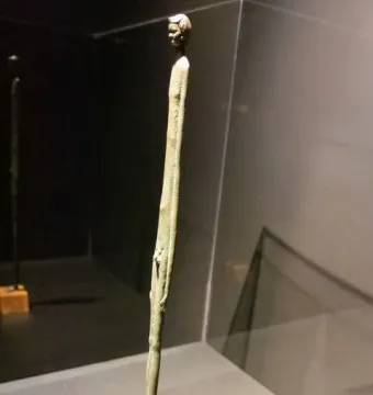 Ombra della Sera bronze figure with an elongated body displayed in a glass case