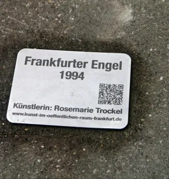 Metal plaque for Frankfurter Engel with the title, year 1994, artist Rosemarie Trockel, website address, and a QR code.