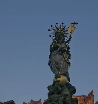 Kornmarkt Madonna sculpture of a crowned woman holding a child, standing on a globe above an ornate base with cherubs.