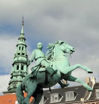 Absalon Monument, a green equestrian statue on a stone pedestal with a tall spire in the background.