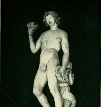 Bacchus statue with grapes in his hair, raising a cup and standing beside a crouching figure reaching for grapes.