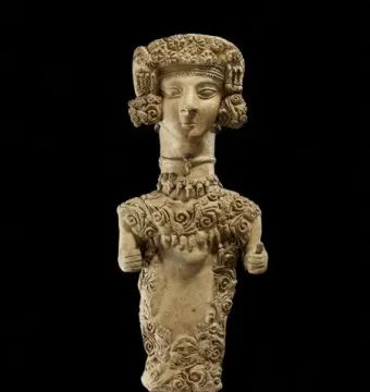Lady of Ibiza clay figure with an elaborate headdress and intricate scrollwork patterns