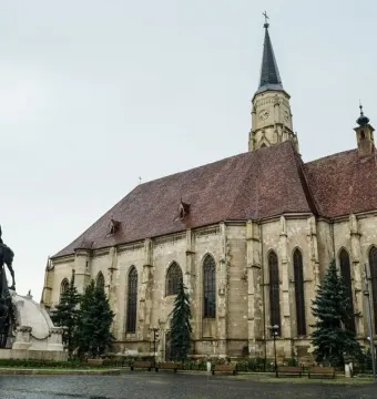 Matthias Corvinus Monument with a bronze equestrian statue and smaller bronze figures in front of a historic church