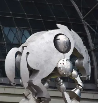 Rolling Horse sculpture on a pedestal in front of a modern glass and steel building.