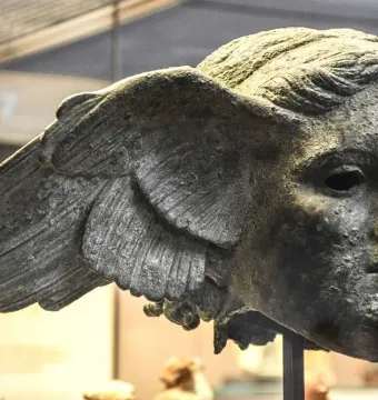 Bronze head of Hypnos with feathered wings at the temples and a weathered patina.