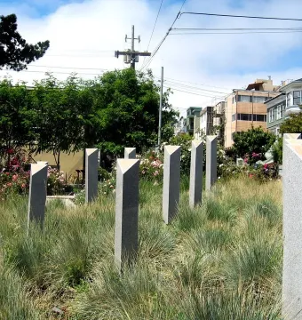 Pink Triangle Park memorial columns with triangular caps among tall grasses
