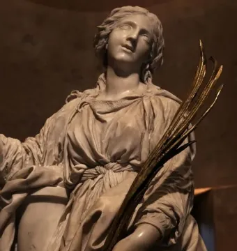 Marble sculpture of St Bibiana looking upward, holding a bundle of golden branches.